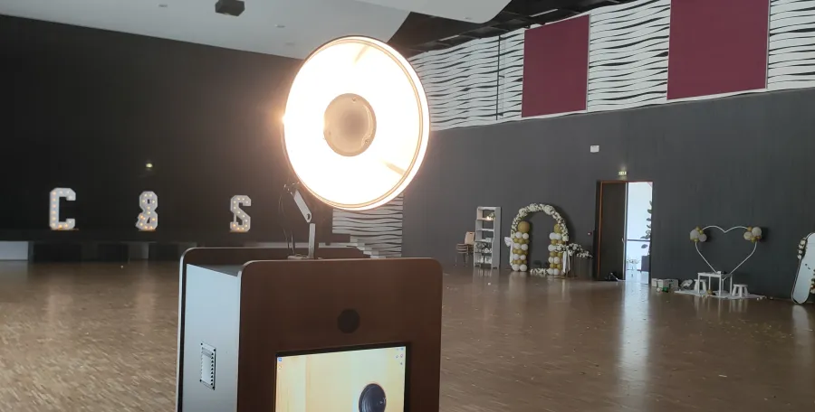 Photobooth Adonis dans une salle de mariage avec arche de ballons et décor cœur